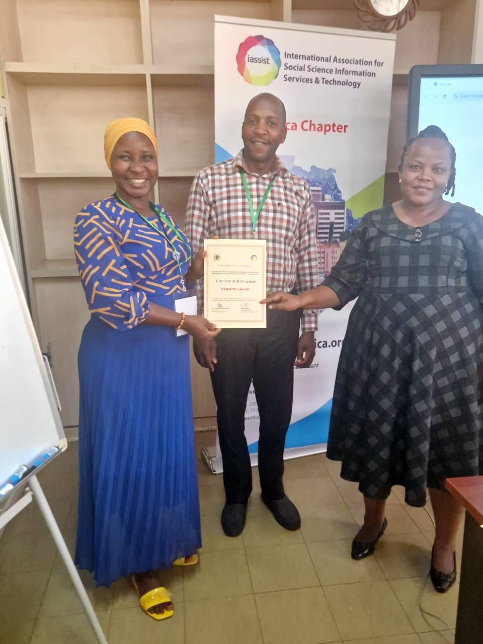 A large conference banner with numerous handwritten greetings and signatures draped across three display stands.