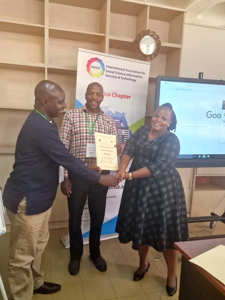 A large conference banner with numerous handwritten greetings and signatures draped across three display stands.